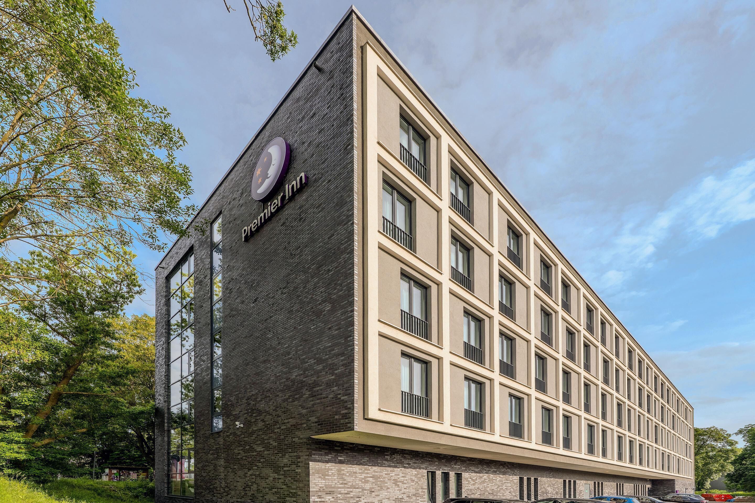 Un edificio moderno con un letrero llamativo de 'Premier Inn' en la fachada.