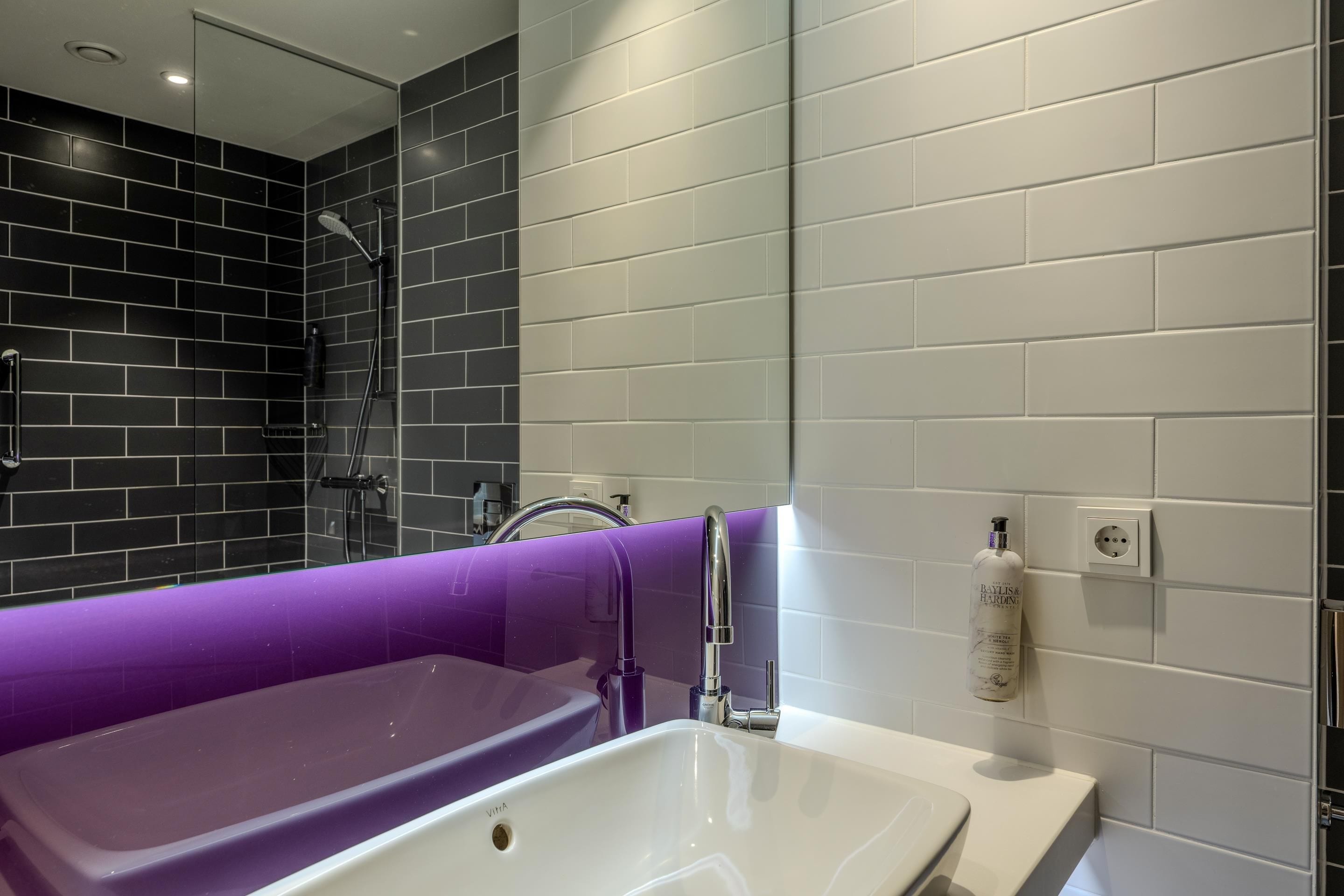 A modern bathroom with a bathtub, shower, and sink.