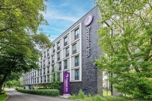 A modern hotel building with a prominent 'Premier Inn' sign, large windows, and a well-maintained exterior.