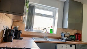 Una cucina con una finestra, un lavello e diversi elettrodomestici.