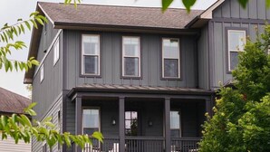 A two-story building with a balcony on the second floor, surrounded by greenery. - New Luxe East Nashville Home • Sleeps 6 Near DWTN (Nashville)