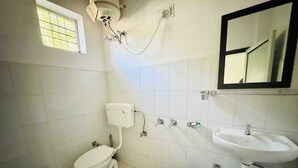 A bathroom with a toilet, sink, and a window.