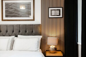 A bedroom with a tufted headboard, a framed quote on the wall, a bedside lamp, and a framed picture above the bed. - Boutique apartment near Old Trafford · terrace · sleeps 6 (Greater Manchester)