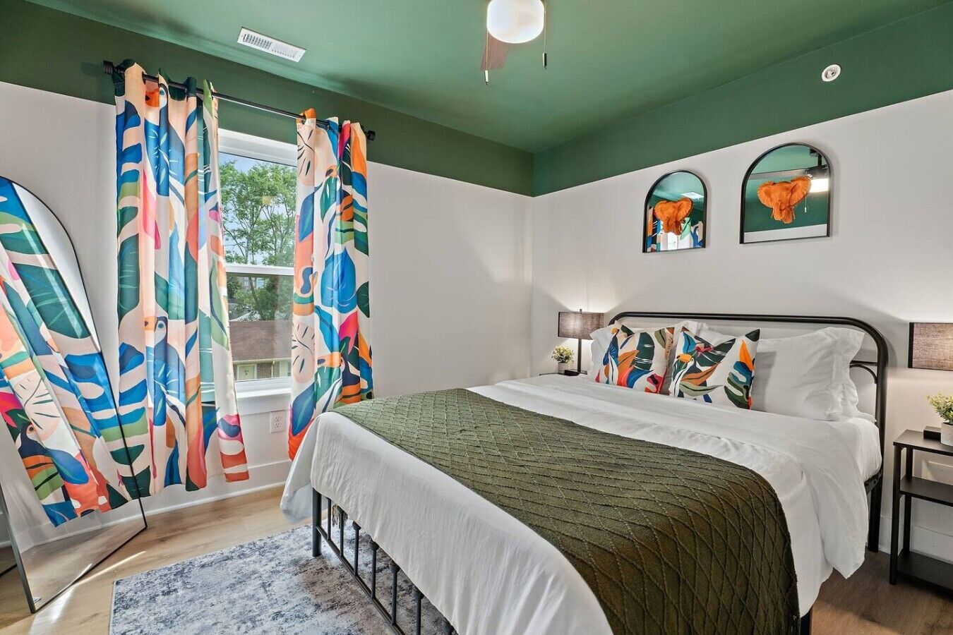 A bedroom with a bed, curtains, a nightstand, and a window.