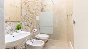 A bathroom with a sink, bidet, and shower. - Hotel Lariana (Rimini)