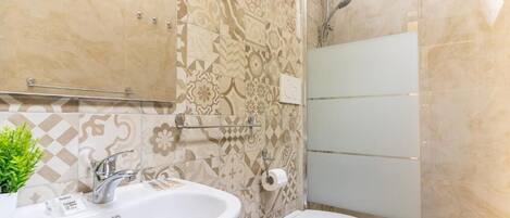 A bathroom with a sink, toilet, and shower.