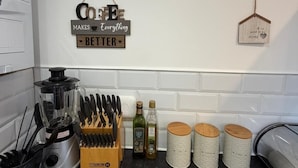 Et køkken med et vægur, en skilt med teksten 'kaffe' og et skilt der siger 'bedre'.