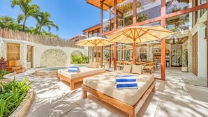 Un resort moderno con mesas al aire libre, piscina y zona de comedor.