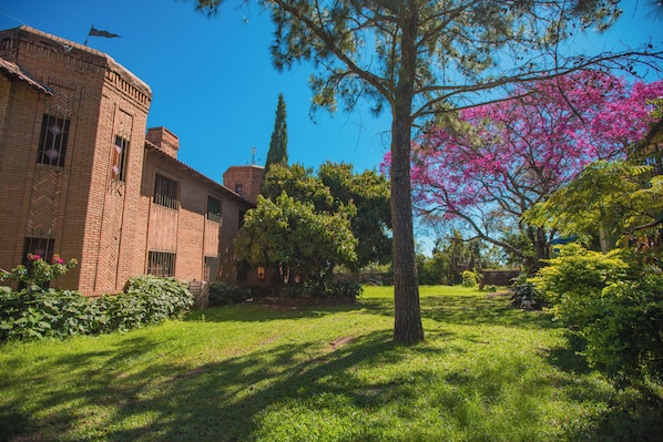 A brick building with a courtyard, surrounded by trees and greenery.