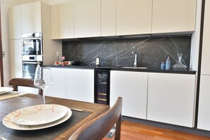 A modern kitchen with white cabinets, a black marble countertop, and stainless steel appliances. - An elegant apartment for up to 4 people, recently renovated with high-quality finishes, including parquet floors throughout. Located in the quaint Vanchiglietta neighborhood, it enjoys an ideal location: just 100 meters from the Lungo Po, perfect for str (Torino)