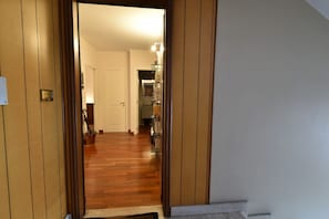 A hallway with wooden paneling, a white door, and a staircase leading to another room. - An elegant apartment for up to 4 people, recently renovated with high-quality finishes, including parquet floors throughout. Located in the quaint Vanchiglietta neighborhood, it enjoys an ideal location: just 100 meters from the Lungo Po, perfect for str (Torino)