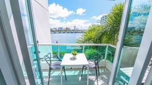 A balcony with a table and chairs, overlooking a body of water and a cityscape. - Centric Paradise Villa with Pool, Whirlpool, Balcony (San Juan)