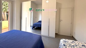 Un dormitorio con cama, armario y puerta que da a otra habitación.