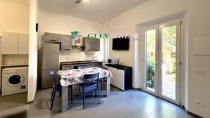 Una cocina compacta con comedor, lavadora y ventilador de techo.