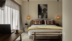 Quarto moderno com um laptop sobre uma escrivaninha de madeira, uma cama com cabeceira, mesas de cabeceira e um ventilador de teto.