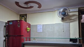 Una habitación con un refrigerador rojo, un ventilador de pared y un gran comedor.