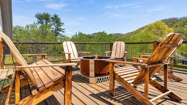Een terras met houten stoelen en een vuurkuil.