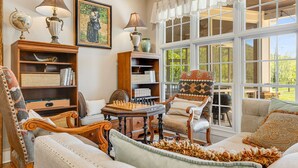 A cozy room with a chessboard, a globe, and a painting on the wall. - Luxury Estate w/ Pool, Hot Tub  Free Tix Sleeps 12 (Fletcher)