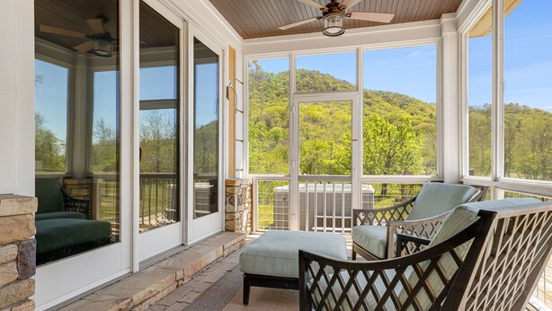 A covered porch with a ceiling fan, stone steps, and a view of a green hillside. - Luxury Estate w/ Pool, Hot Tub  Free Tix Sleeps 12 (Fletcher)