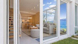 Un interno moderno con cucina, zona pranzo e soggiorno con vista sul mare.