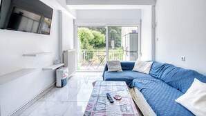 Ein modernes Wohnzimmer mit einer Couch, einem Couchtisch und einem Fernseher.