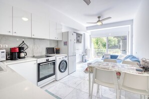 Une cuisine moderne Ă©quipĂ©e dâun lave-linge, dâun four et dâune machine Ă cafĂ©.