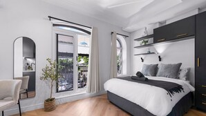 Una camera da letto moderna con un letto grande, una scrivania e vista panoramica tramite una porta scorrevole.