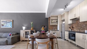 Eine moderne Küche mit Essbereich, grauen Wänden und einem grauen Sofa.
