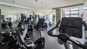 Ein Fitnessstudio mit unterschiedlichen Trainingsgeräten, großen Fenstern und einem modernen Design.