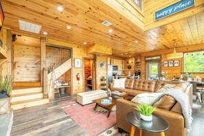 Ein Holzblockbau-Innenraum mit Treppe, Wohnbereich, Essbereich und Küche.