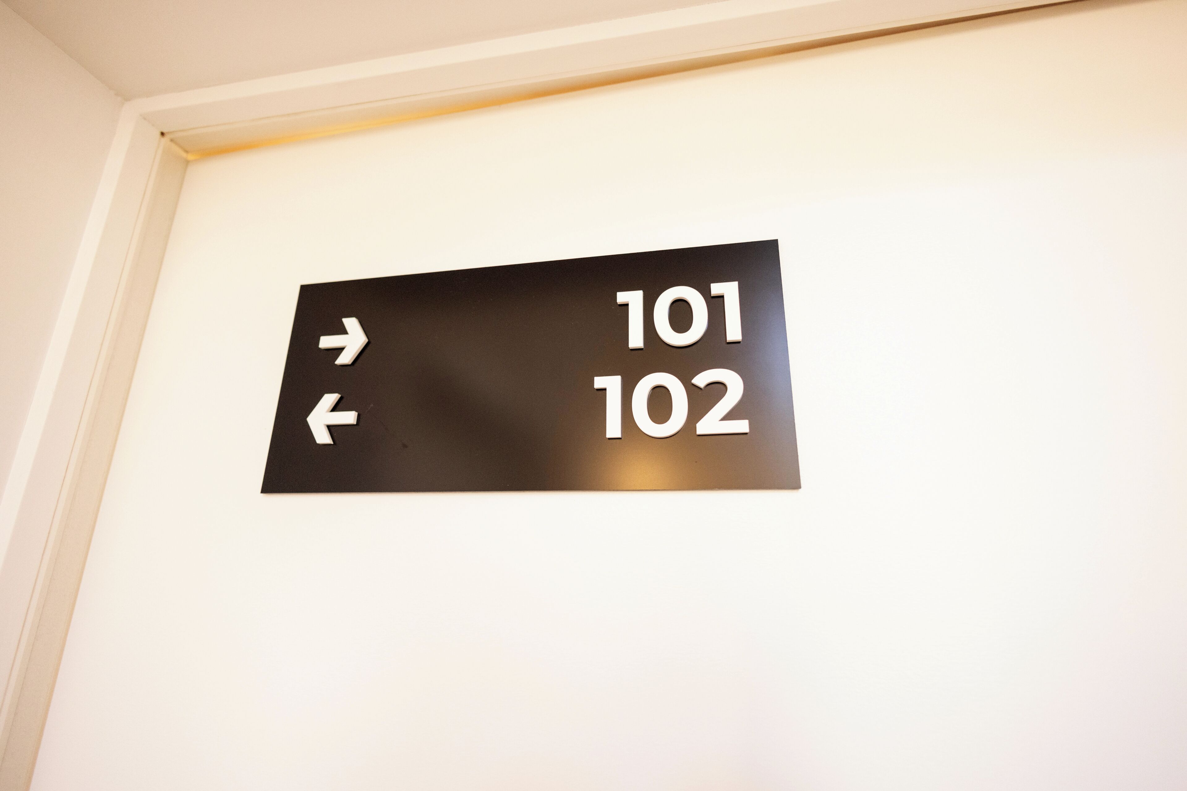 Een wijzertje met de nummers 101 en 102, dat kamernummers of richtingen aangeeft.