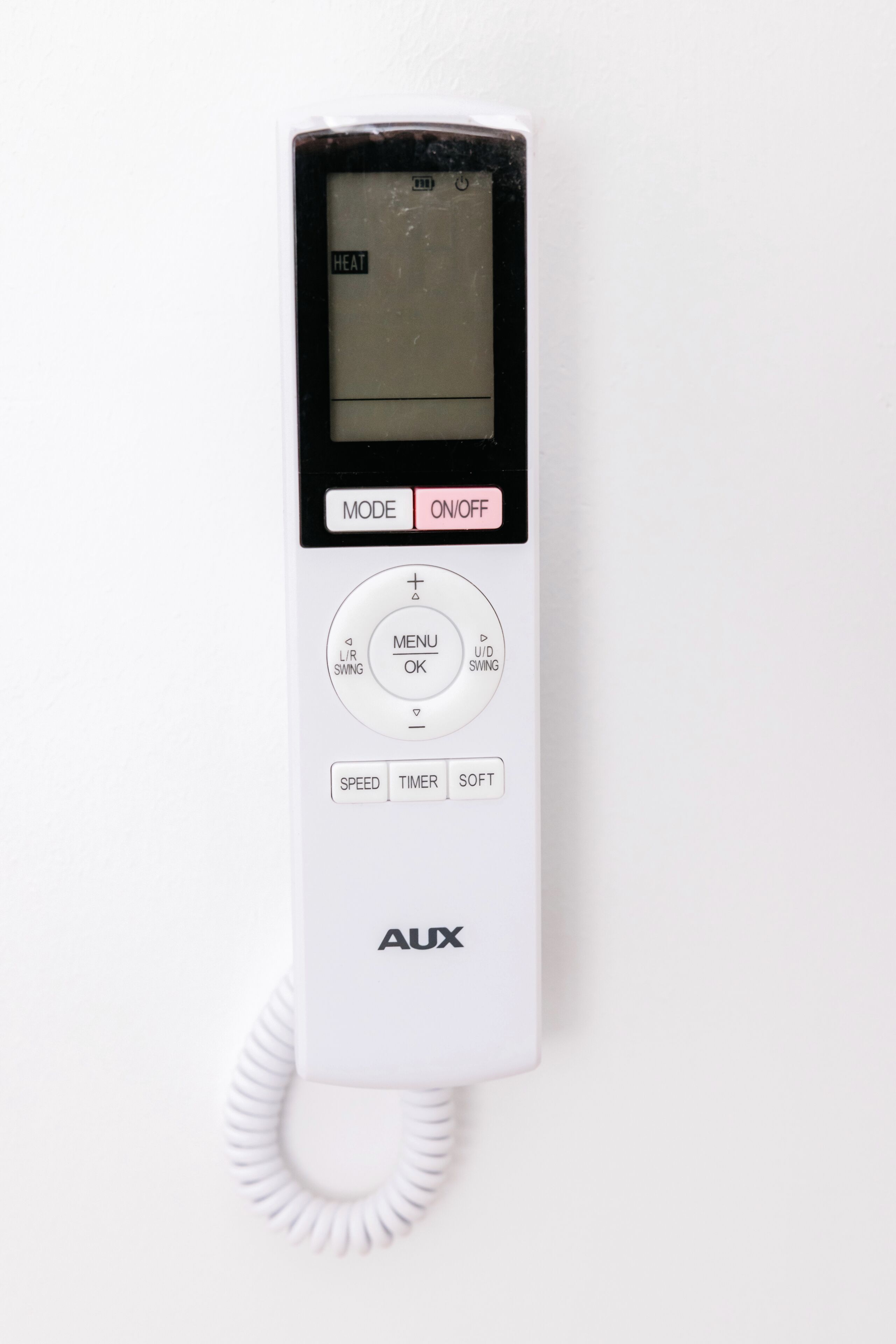 Teléfono blanco instalado en la pared con cable enrollado, que incluye pantalla digital, interruptor de modo, botón de menú, velocidad, temporizador y botón suave.