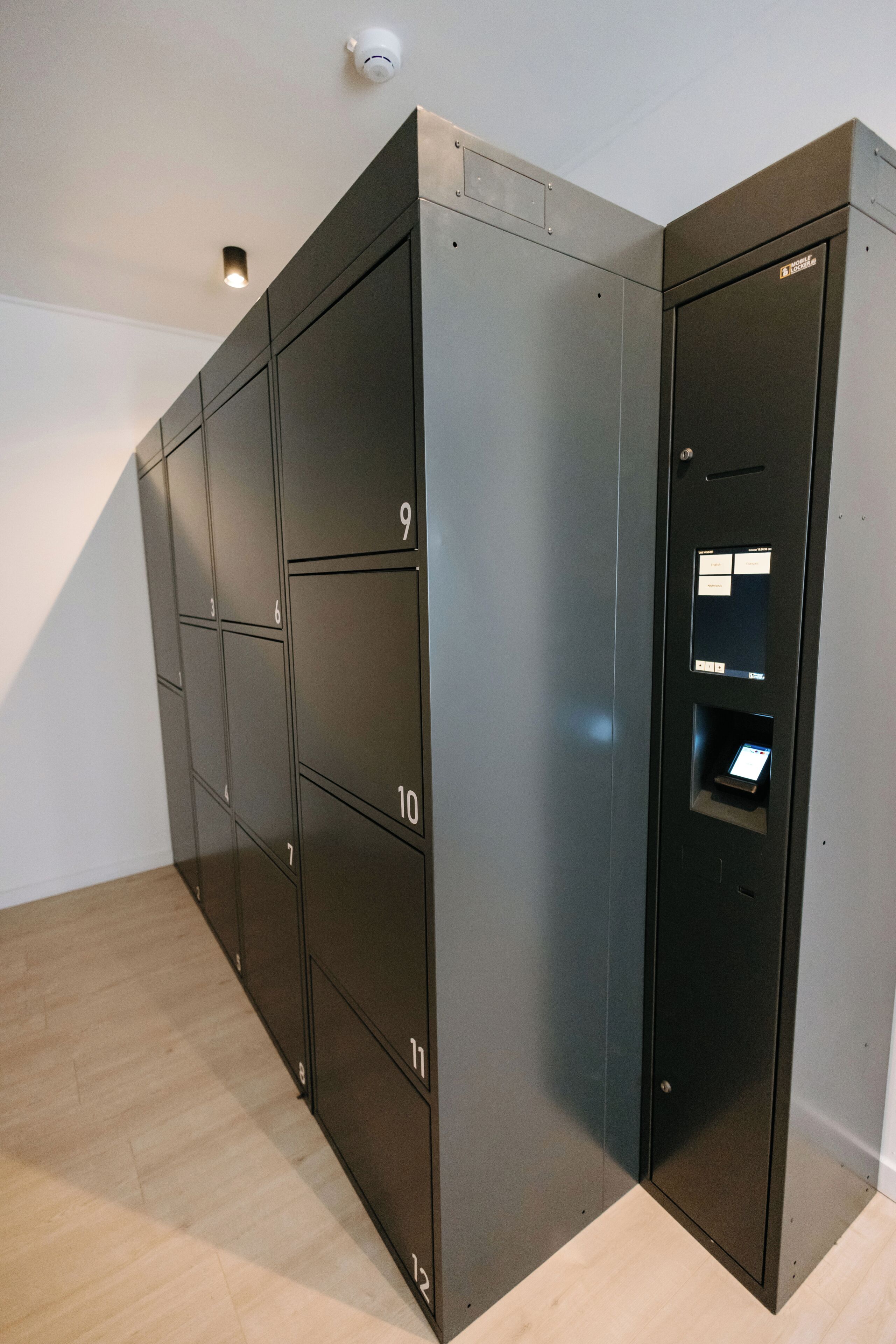 A row of numbered lockers, likely for storage or mail, in a modern interior with a light-colored floor.