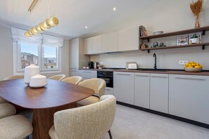 Une cuisine moderne avec une table à manger, des chaises et une vue sur la ville.