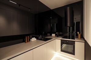 Eine moderne Küche mit Backofen, Kaffeemaschine und einer eleganten Arbeitsplatte.