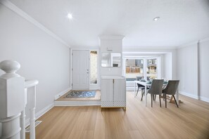 Ein modernes Interieur mit Treppe, Essbereich und Ausblick nach draußen.