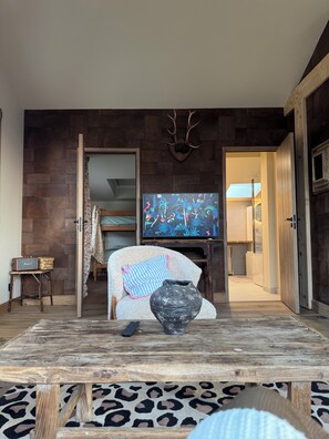 A living room with a television, a vase, and a leopard print rug. - Fisherman's house facing the sea (Saint-Côme-de-Fresné)