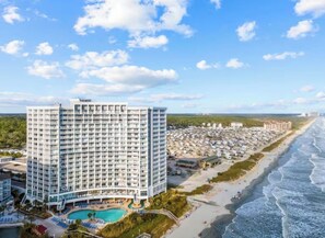 Ein hoch aufragendes Hotel mit Pool, Blick auf den Strand und einer Strandlage.