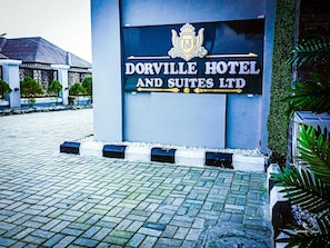 Ein Schild des Dorville Hotels mit einem Wappen-Logo, das auf ein Unternehmen für Hotels und Suiten hinweist.