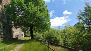 Ein Steinhaus mit einem Weg, der zu einem Holzzaun führt.