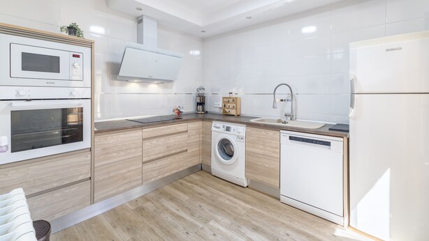 A modern kitchen with built-in appliances, a dishwasher, and a microwave.