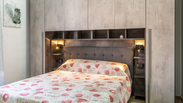 A bedroom with a bed, a headboard, bedside tables, and wall-mounted lighting. - La Capinera by Wonderful Italy (Noto)