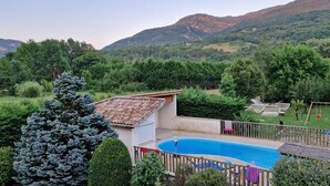 Zona residencial con piscina, patio cercado y vista a montañas.