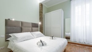 Quarto com cama, guarda-roupa, banheiro e cortina de chuveiro.