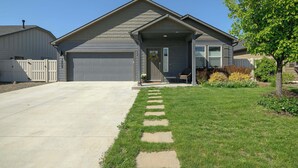 Una casa residenziale con garage, portico anteriore e prato curato.