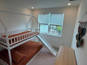 A bunk bed with a window, a small table, and a wall-mounted macrame. - Turtle Nest Paradise - Quick Walk to Sand (Fort Myers Beach)
