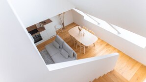 En modern lägenhet i loftstil med matplats, kök och vardagsrum.