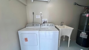 A laundry area with two white washers and a small sink. - Chill Vibes A - 2 min to Beach (Fort Myers Beach)