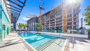 Ein Swimmingpool mit Sonnenschirm, umgeben von einem Baugebäude mit Gerüst.
