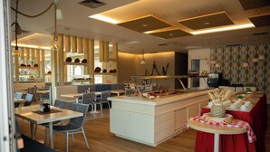 Un restaurant moderne doté d’un îlot central, de différents espaces de restauration et d’un espace cuisine.